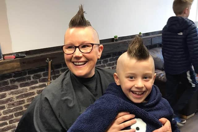 Emma Rhodes and son Loki pictured with mohawks midway through their head shave.