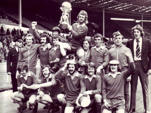 Morecambe players celebrate at Wembley with their FA Trophy in 1974.