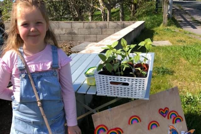 Lilabelle Bibby with her stall outside her home selling rainbows and sunflowers.