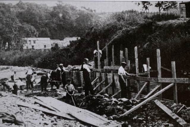 The photograph shows the foundations being laid for Ingleton's swimming pool. As part of the pool was set in the riverbed, some said it would not withstand the destructive force of the rover. Photograph taken from the book 'Old Ingleton' by kind permission of John Bentley. Photography by Anthony Brown.