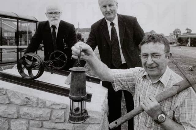 Unveiling the memorial to Ingleton's coal industry. From left: John Bentley, Phil Walker (chairman of the parish council) and Bernard Bond who Phil Walker stated, had with determination and perseverance unearthed the history of mining in the area which culminated in the creation of the memorial to serve as a visual reminder of the coal mining industry. Photograph: Craven Herald and Pioneer, June 2004.