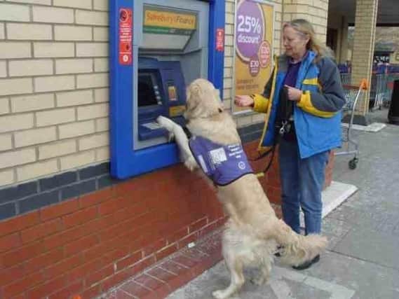 Teddy helps Wendy at a cashpoint.