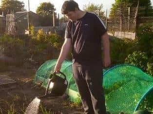 Harry Stafford watering plants at his allotment.