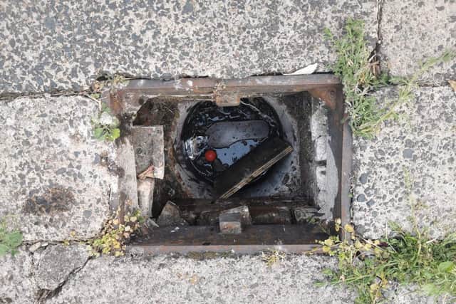 The manhole Tracey Mcculloch fell down. Her flip flop is visible at the bottom of the drain.