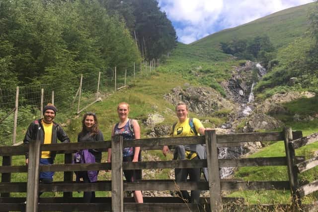 Hikers James March, Charlotte March, Louise Quinn and Katie McTernan take in a waterfall on their descent from Helvellyn.
