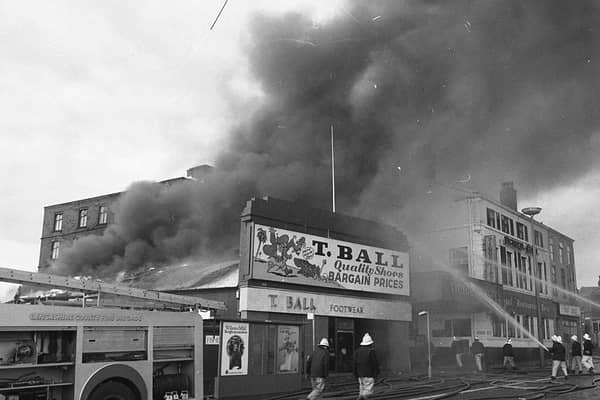 Thick black smoke can be seen billowing from the huge fire at T. Ball Shoe Shop