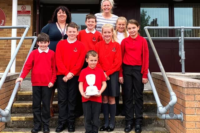 Staff and pupils at Trumacar Primary School with the AV1 robot.