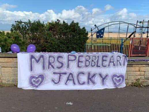 Purple pebbles on the wall near the Battery in Morecambe for Morecambe's 'Mrs Pebbleart' Jacky Burns whose funeral was on Thursday.