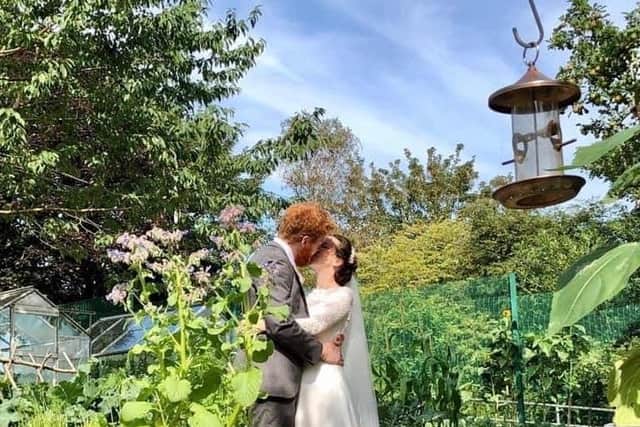 Ruth and Phelim Kennedy seal their lockdown wedding with a kiss in St Joseph's new community garden.