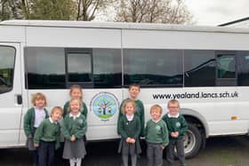Schoolchildren at Yealand C of E Primary school next to their minibus which costs £1000 a year to run. The school is holding an online promise auction to raise money to keep their minibus running.