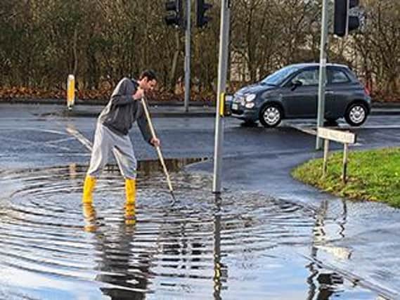 Skerton West ward councillor Phillip Black clearing the blocked drains on Sunday.
