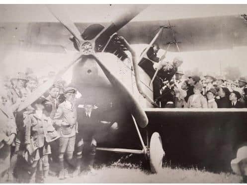 Arthur Long's biplane safely on the ground at Highfield, surrounded by schoolkids from Stanley.(Supplied: Queen Victoria Museum And Art Gallery)
