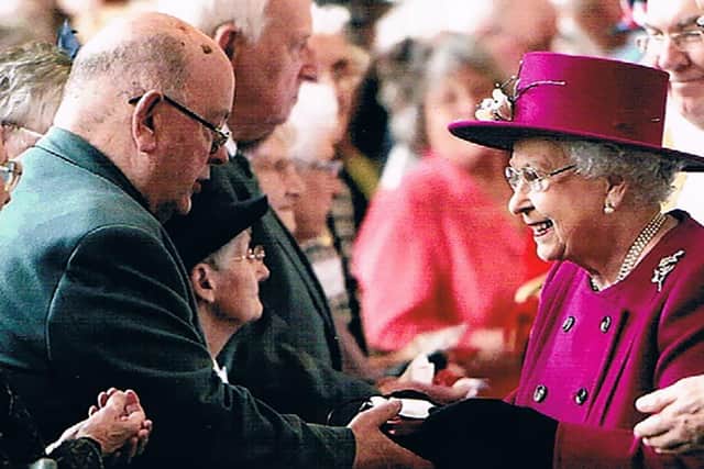 One of Canon Ron's treasured photos shows him receiving Maundy money from the Queen at Blackburn Cathedral