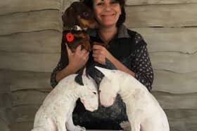 Christine Cummings holding her pet dog Frank, showcasing two of her ceramic pieces. Artist Christine is auctioning off the chance to someone to get a ceramic model made of their pet, to raise money for sight loss charity Galloways