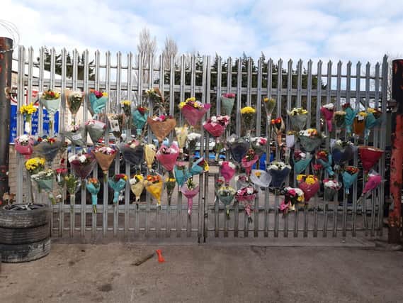 Dozens of floral tributes adorned the gates of Ken Allen Auto Wreckers on White Lund after the news broke.