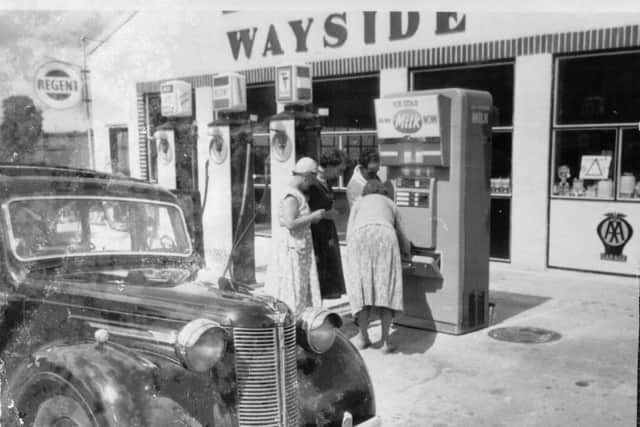Wayside Garage circa 1960. Brian Leach's father is showing three ladies how to obtain milk from the ‘state of the art’ machine, generally referred to as the ‘Iron Cow’.