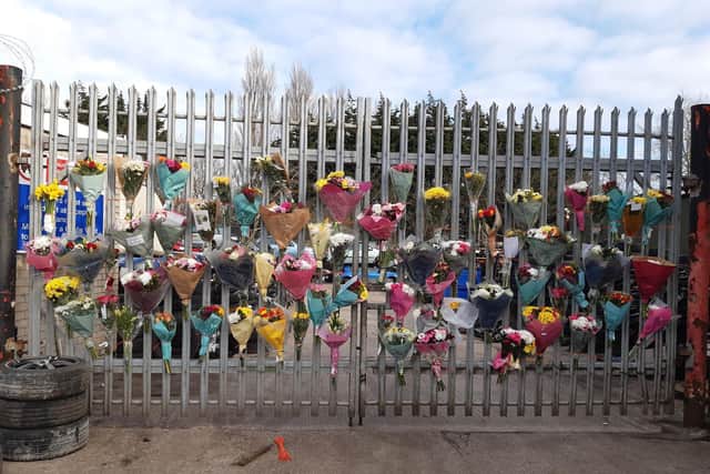 Floral tributes on the gates of Ken Allen Auto Wreckers on White Lund.