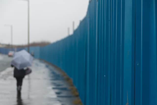 Several panels of blue fencing are currently being repaired or replaced.