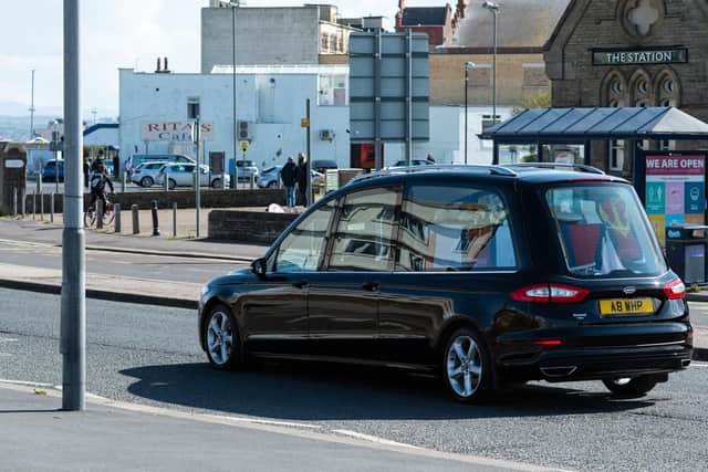 The funeral car passes along Morecambe prom.