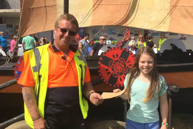 Peter presenting an award for best shield design to Annalise McVernon of St Peter's C ofE Primary School at the 2016 Viking Festival.