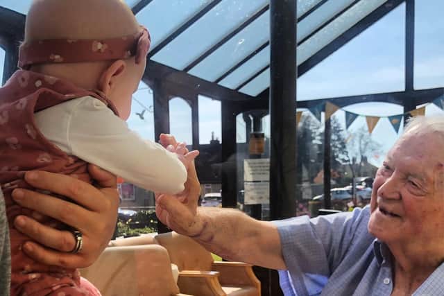 Tom Hanley meets his great-granddaughter Georgie Goodman for the first time recently through a perspex screen.