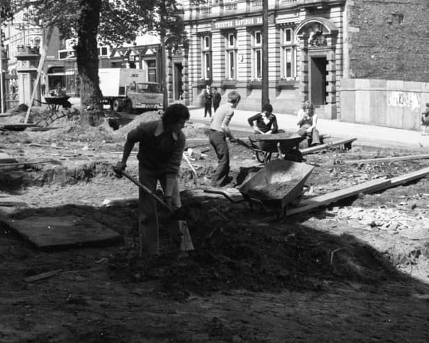 Men start work at Preston Parish Church, digging up ancient tombstones during landscaping