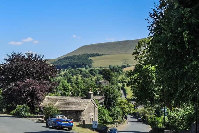 One of the walks explores the foothills of Pendle  starting in the historic village of Downham (pictured)