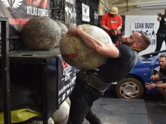 Tim loading an Under 80kg World Record atlas stone - weighing 165kg.