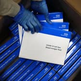 A health worker removes Covid-19 test kits from a box at a NHS Test and Trace Covid-19 testing unit.  (Photo by ADRIAN DENNIS / AFP) (Photo by ADRIAN DENNIS/AFP via Getty Images)