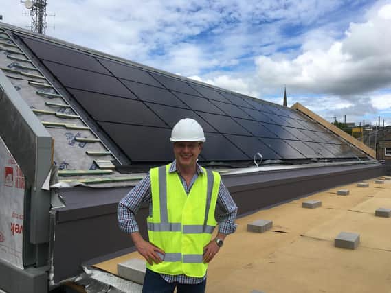 Vicar Jon Scamman by the solar panal roofing on the new St Thomas church centre.