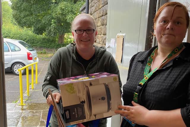 Clare Southworth hands over one of the slow cookers to a resident.