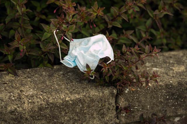 A discarded PPE (personal protective equipment) face mask is pictured littered in a hedgerow. Wilko Lancaster is running a scheme where customers can recycle used facemasks at the store. (Photo by Oli SCARFF / AFP) (Photo by OLI SCARFF/AFP via Getty Images)