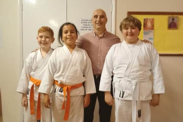 Reuben McLoughlin, right, gained his orange belt  while Jake Lamourie and Val Sommerville were promoted to red belts