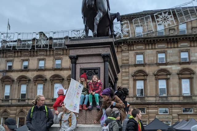 Isla Bradbury and Esme Donald both pupils of St Wilfrid's Primary in Halton with their banner as they climbed on a statue during Greta's march in Glasgow for COP26.