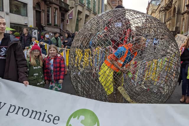 Isla Bradbury and Esme Donald both pupils of St Wilfrid's Primary in Halton with the metal ball they got into made by a man who travelled around Europe. The schoolgirls took part in Greta's march in Glasgow as part of COP 26.