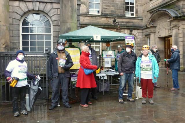 Braving the wet weather on Saturday to hold fort at the stall in Market Square.