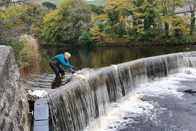 Settle Hydro volunteer works on the weir.