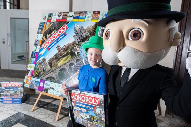 Competition winner James Jones-Turner, five, with Mr Monopoly and his copy of the Lancaster board game.