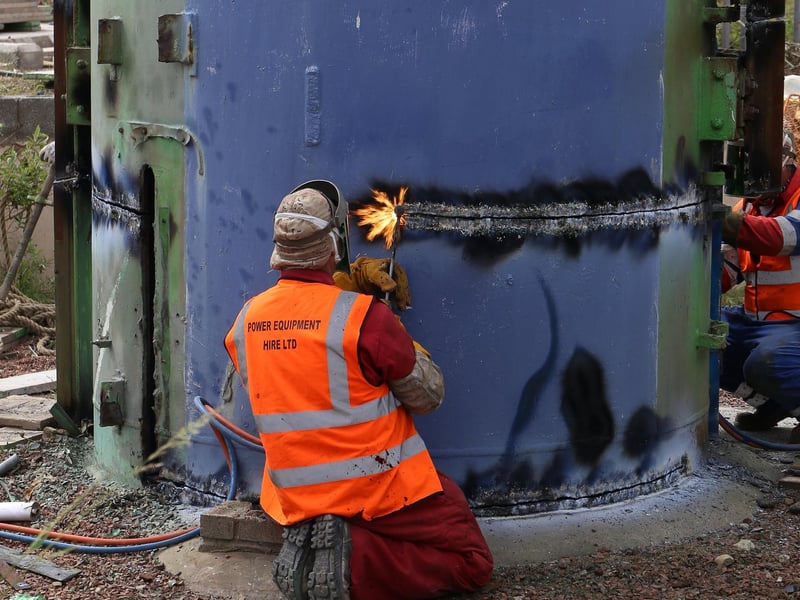 Workmen get to work on the removal of the base.