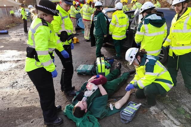 Students attending to a road traffic accident victim on the ground.