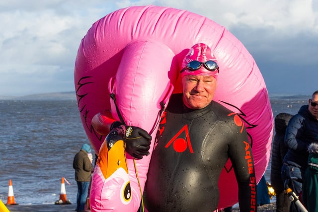 A man carries an inflatable pink flamingo for his dip in the bay. Picture by Keith Douglas.