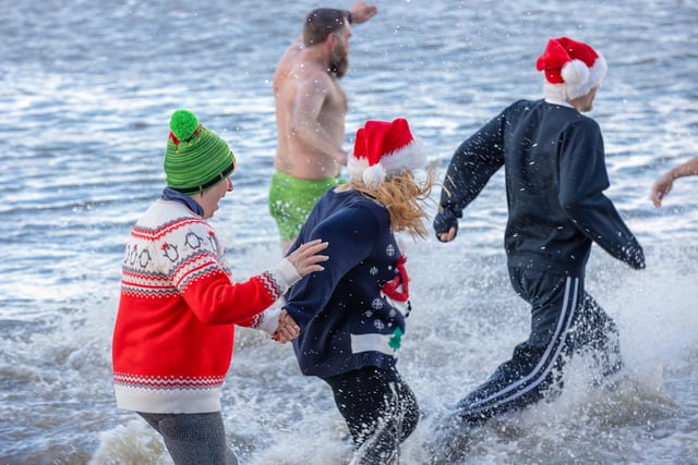People with Christmas jumpers and tracksuit bottoms brave the cold sea for the dip. Picture by Jamie Buttershaw.