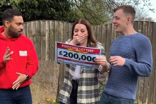 Ria and Ross Plawecki receive their prize from Danyl Johnson of the People's Postcode Lottery. Image from People's Postcode Lottery