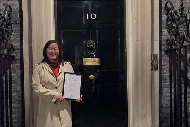 Anna Chan, 34, standing outside number 10 Downing street with her award certificate.