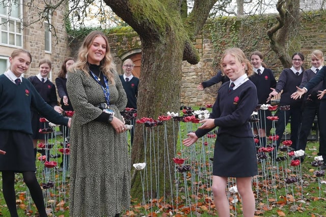 Art teacher Emma Field with some of the pupils who took part in making the poppy display.