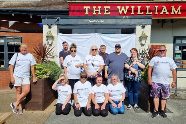 The William Mitchell staff team with Tricia (front row in sunglasses) and Maria, next to hubby Ben, with their 14-week-old baby son Harry.