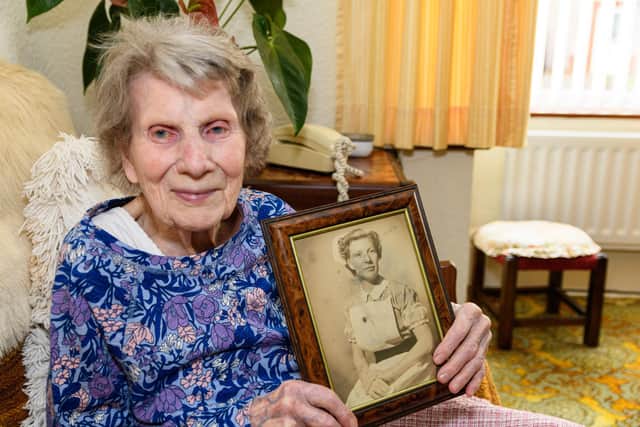 Heysham resident Meg Phillips, who is turning 100 on June 3, pictured with a photo of herself as a nurse in her younger days. Photo: Kelvin Stuttard
