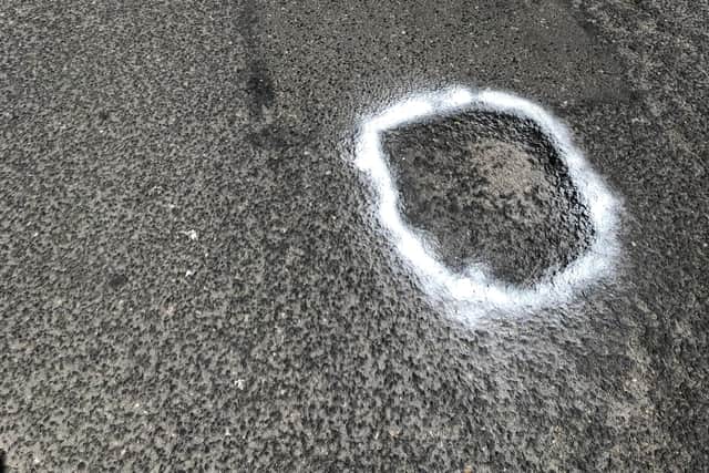 Potholes on Poulton Road, Morecambe have been circled with chalk to highlight them.