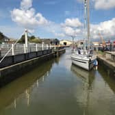 A smaller boat enters Glasson Marina through a lock connecting from Glasson Dock.