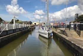 A smaller boat enters Glasson Marina through a lock connecting from Glasson Dock.
